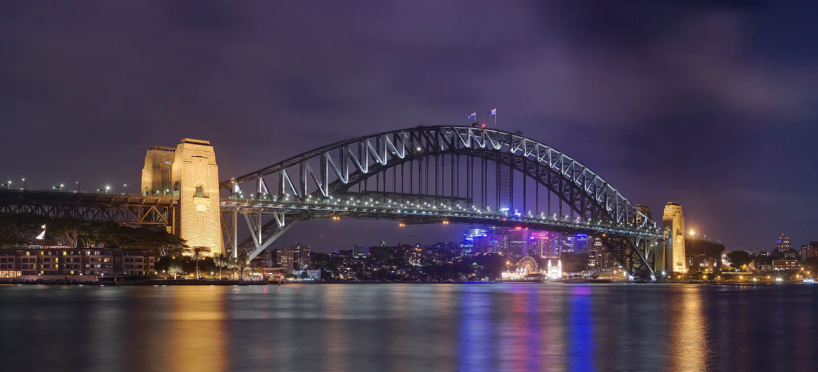 Sydney Harbour Bridge viewed from Circular Quay with ferry wharves and harbor water in the foreground